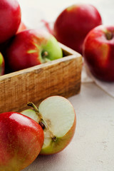 Harvest fresh ripe red apples in a wooden box on a white background top view.Organic vegetarian produce.Vertical orientation