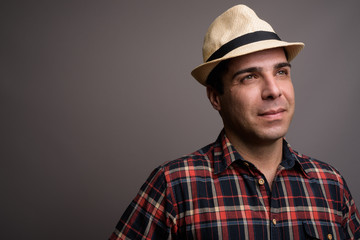 Handsome Persian tourist man ready for vacation against gray bac