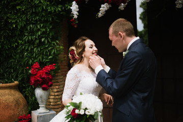 The groom in a suit and the bride in a wedding dress are standing at the wedding arch at the wedding ceremony