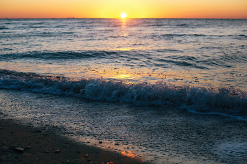 Beautiful sea waves foam closeup and red sky with sun in sunrise light on tropical island. Waves in ocean at sunset. Tranquil calm moment. Summer vacation. Copy space