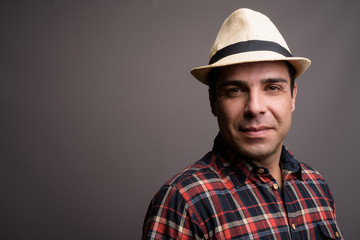 Handsome Persian tourist man ready for vacation against gray bac