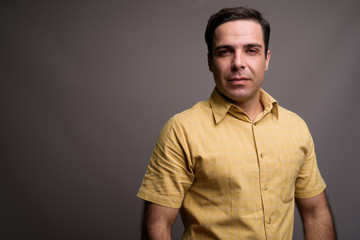 Portrait of handsome Persian man against gray background