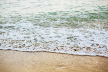 Beautiful sea waves foam closeup and sandy beach with seashells on tropical island. Waves in ocean bay or lagoon. Tranquil calm moment. Summer vacation. Copy space
