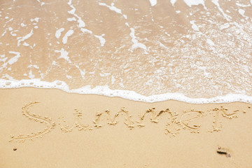 Fototapeta na wymiar Summer sign on beach. Written summer text word on sandy beach and sea waves with foam. Hello summer concept. Top view. Vacation, relax and travel. Copy space