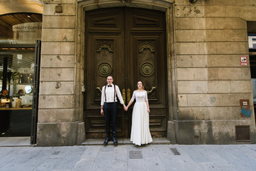 Naklejka premium Bride and groom posing on city streets