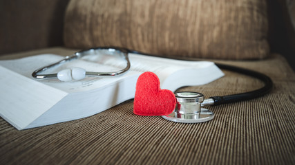 Closs up red heart and stethoscope with bible, concept of Jesus christ the savior liberate people...
