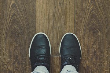 Footwear concept. Top view of men's black shoes. Man making photo of his fashionable shoes isolated on wooden.