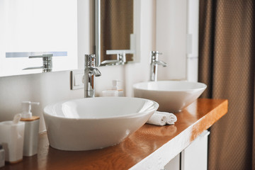 Naklejka na ściany i meble Modern stylish washbasins with chrome taps. Contemporary interior. Luxury lifestyle. Wood texture