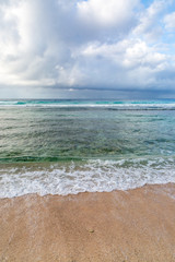 Fototapeta na wymiar Waves lapping a sandy beach on the Caribbean island of Barbados
