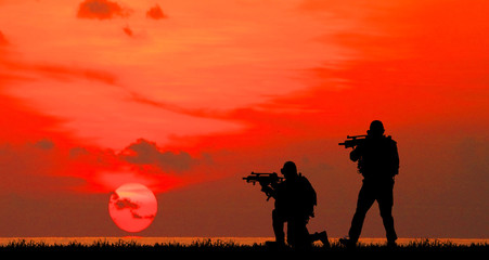 Silhouette of soldier with rifle on a sunset