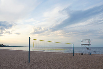 Sports volleyball net and rescue tower on a sandy beach