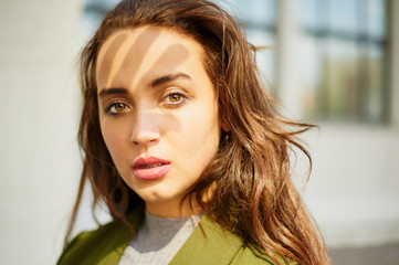 Believer. Close up portrait of woman. Lady looking in camera. Shadow of hand on her face.