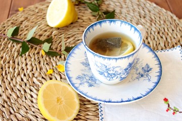 Infusión de te verde con limon con taza de porcelana vintage en colores azules