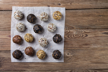 A group of energy balls lying on parchment paper. Wooden background. The concept of healthy eating.