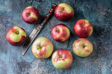 Red apples on dark blue concrete background. Autumn fruit harvest