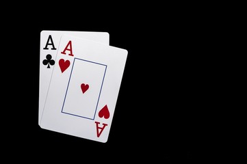 Two aces playing cards on black table