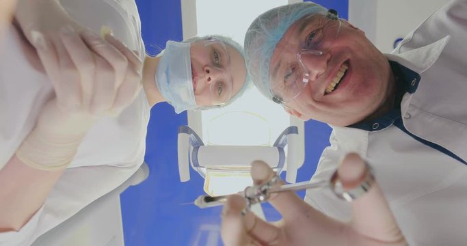 Concept of fear of dentists. Doctor smiles diabolically holding syringe for tooth operation