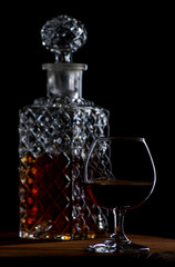 Obraz na płótnie Canvas Brandy or cognac in glasses and a decanter on a brown wooden background