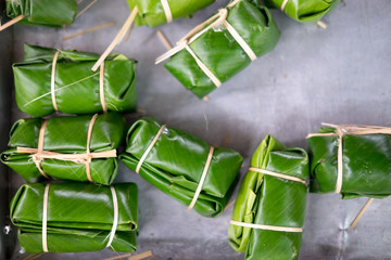 Banana with sticky rice covered in banana leaf before steamer.