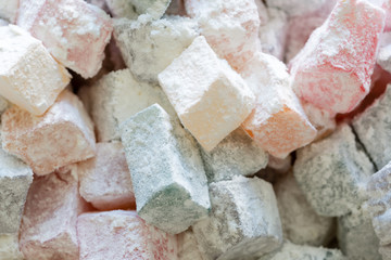 Turkish delight colorful pieces in powdered sugar. Rahat lokum traditional Turkish sweets, Turkey. Close up image.