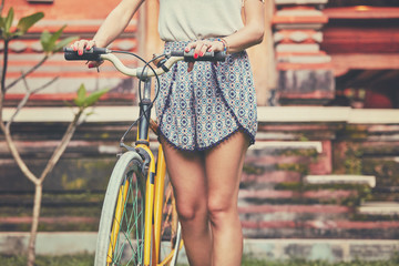 Naklejka premium Pretty woman sitting with old bicycle outdoors.