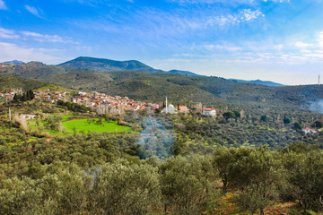 Village in the forest. Blue sky. Between the mountains and olive trees.