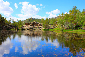 Obraz premium calm lake among rocky mountains with trees