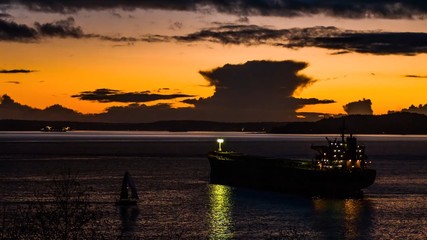 Fototapeta na wymiar Oil ship and sailboat on front sunset of sea 