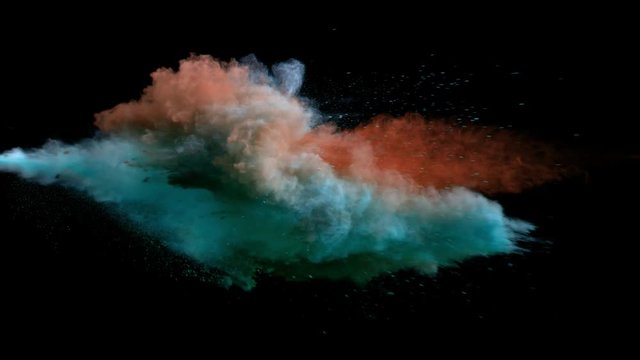 Super slow motion of coloured powder collision isolated on black background. Filmed on high speed cinema camera, 1000fps.