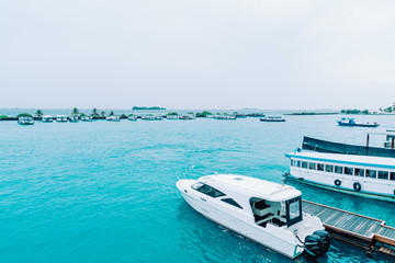 Fototapeta na wymiar HULHULE, MALDIVES - MAY 23, 2019: Boats and ferries at the harbor outside Velana airport in Hulhule.