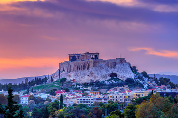 The Acropolis of Athens city in Greece with the Parthenon Temple (dedicated to goddess Athena) as seen from the Panathenaic Stadium, at sunset time with colorful cloudy sky. Scenic urban view at dusk