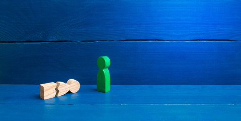 A figurine of a green man stands over a fallen split man. The concept of mutual aid, first aid. Social protection and caring. Psychological and physical rehabilitation. banner, place for text