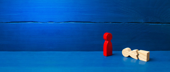 A figurine of a red man stands over a fallen split man. The concept of mutual aid, first aid. Social protection and caring. Psychological and physical rehabilitation. banner, place for text