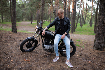 Portrait hipster young guy with a beard and mustache with sunglasses, street casual a motorcycle