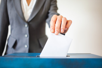elections - The hand of woman putting her vote in the ballot box