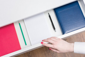 Woman open shelf with notebooks and pens, top view, copy space, advertising