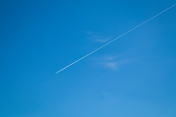 Airplane flying across a solid blue sky