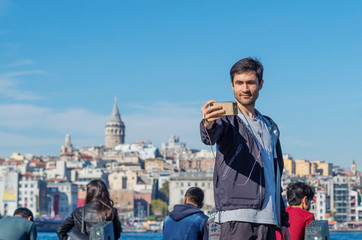 A handsome man taking a selfie picture in Istanbul, Turkey. Man on a sunny quay enjoying happy...
