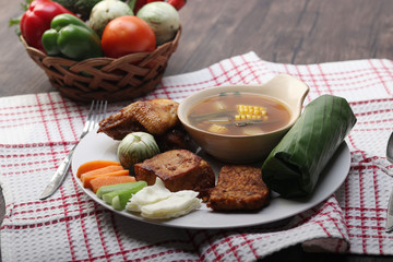 lunch package containing rice, fried chicken, vegetable tamarind, tempeh and tofu