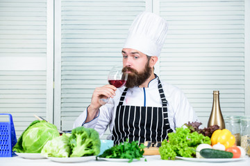 Match wine and food like expert. Man wear hat and apron enjoy taste drink. Master chef hold glass of wine. Add bit of alcohol. Which wine serve with dinner. Wine degustation. Haute cuisine concept