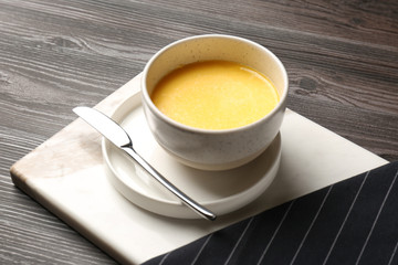 Bowl of melting butter served on wooden table