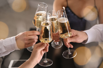 Friends clinking glasses of champagne in restaurant, closeup - Powered by Adobe