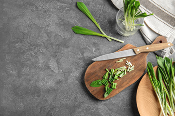 Flat lay composition wild garlic or ramson on grey table. Space for text