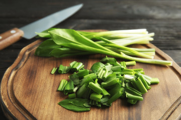 Board with wild garlic or ramson on table, closeup