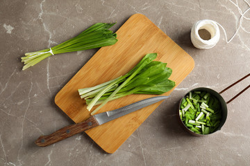 Flat lay composition with wild garlic or ramson on grey table