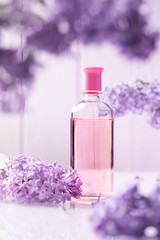 Obraz na płótnie Canvas perfume bottle with lilac flowers on white background