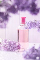 perfume bottle with lilac flowers on white background
