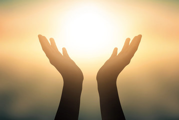 Free concept: Raised hands catching sun on sunset sky - Powered by Adobe