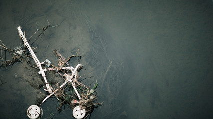 Ruined baby stroller in river