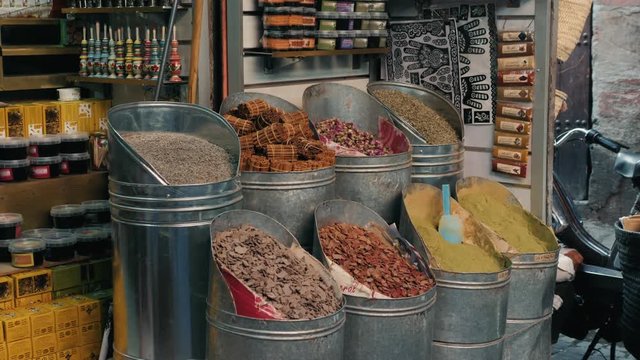 Selection of different arabian spices on a traditional Moroccan market souk in Marrakech, Morocco. A lot of pepper, cardamon, cumin, curry